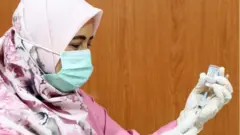 Petugas kesehatan dengan vaksin Moderna.