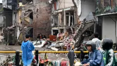 Vista de uma ponte com uma rua inundada e casas parcialmente derrubadas