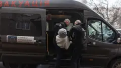 Trabalhadores da organização East SOS evacuam Valentina, de 92 anos, devido aos contínuos ataques russos à cidade de Sloviansk