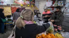 Una mujer compra frutas y verduras en Teherán.