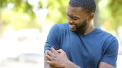 Un homme qui se gratte le bras