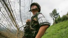 
Un soldat sud-coréen regarde à travers la grille qui sépare les deux pays.