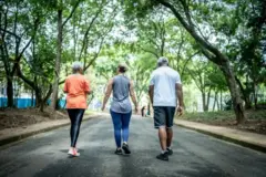Três pessoas caminhando num parque