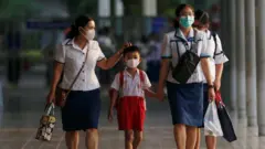 Étudiants et personnel scolaire à Bangkok alors que la Thaïlande annonce une fermeture des écoles pour une durée de 14 jours