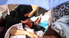 امرأة تستخدم مروحة محمولة تعمل ببطارية لإسعاف رجل مغشيّ عليه أثناء شعيرة رمي الجمرات