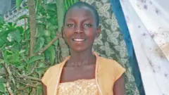 Monic sarı bir tişört ve üzerine sarı yelek giyiyor