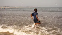 ਸਮੁੰਦਰ ਕਿਨਾਰੇ ਖੜ੍ਹਾ ਬੱਚਾ 