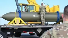 Personal militar estadounidense manejando una bomba de penetración masiva de municiones (MOP) colocada sobre un camión