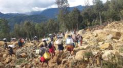 Pessoas carregam sacolas nas costas enquanto caminham por terreno coberto por pedras na província de Enga, Papua Nova Guiné
