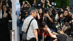 一名宏福苑居民到位於中環展城館聽證會現場,接受在場多間傳媒訪問。