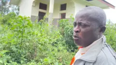 Kitsa Floribert, le directeur de l'EP Kalembo, devant la porte de son bureau fermé