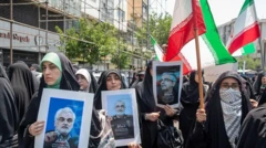 تجمع تعدادی از حامیان جمهوری اسلامی با تصاویری از کشته‌شدگان و پرچم جمهوری اسلامی در دست