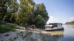 Cidadãos de Liberland transportam alimentos e equipamentos no navio Swan.