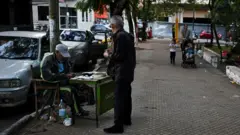 Un hombre cuenta billetes de guaraníes en una calle de Asunción