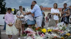 مردم در مراسم یک دقیقه سکوت به یاد قربانیان حمله در ساحل بوندی ایستاده اند. 