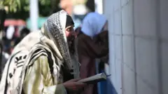 Um homem com um livro na mão rezando