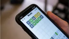 A woman playing Wordle on her phone onboard a London tube train