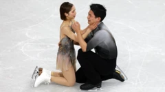 Японские фигуристы на льду на коленях после выступления