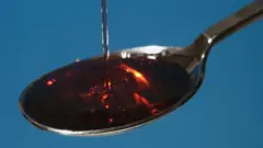 Cough syrup poured onto spoon, close-up