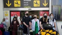 Turistas chegando a aeroporto na Espanha