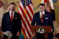 El fiscal general interino, Todd Blanche, habla desde un podio acompañado por el fiscal federal para el Distrito Sur de Florida, Jason A. Reding Quinones, y la presidenta de Miami Dade College, Madeline Pumariega.
