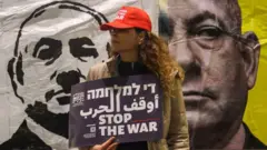 Пикетчица за окончание войны на фоне изображений Нетаньяху