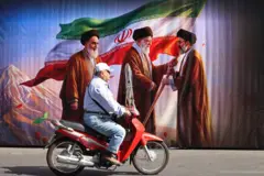 جدارية تظهر صورة من اليمين إلى اليسار مجتبى خامنئي وعلي خامنئي وروح الله الخميني في شارع في طهران