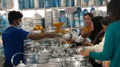 পূর্বাচলে বাণিজ্য মেলায় পণ্য দেখছেন কয়েকজন ক্রেতা