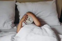 chłopiec z budzikiem w łóżku