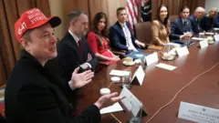  كبير مستشاري البيت الأبيض، والرئيس التنفيذي لشركتي تسلا وسبيس إكس، إيلون ماسك (يسارًا)، يتحدث خلال اجتماع لمجلس الوزراء عقده الرئيس الأميركي دونالد ترامب في البيت الأبيض، في 24 مارس/آذار 2025