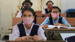 Students wearing facemasks maintain social distance while attending class at a government girls high school amid the ongoing Covid-19 coronavirus pandemic, in Hyderabad on March 17, 2021.