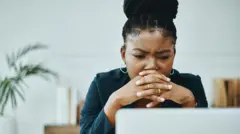Shot of a young businesswoman frowning while using a laptop in a modern office