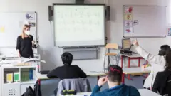 Alunos separados e com máscara em sala de aula