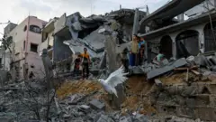 پرواز یک کبوتران از روی آوار خانه‌ها در خان یونس در جنوب نوار غزه