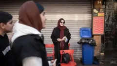 دو زن و یک مرد جوان در پیادهرو