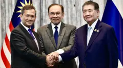 นายฮุน มาเนต นายกฯ กัมพูชา จับมือกับนายภูมิธรรม เวชยชัย รักษาการราชการแทนนายกฯ ไทย ภายหลังร่วมแถลงข่าวบรรลุข้อตกลงหยุดยิง โดยมีนายกฯ มาเลเซียเป็นผู้อำนวยความสะดวก