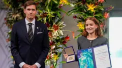 La hija de maría corina machado, ana corina sosa machado, sostiene el premio nobel de la paz.