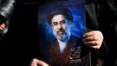 امرأة تحمل صورة للمرشد الأعلى الإيراني الجديد، مجتبى خامنئي، خلال تجمع لدعمه في طهران بإيران، في ظل الصراع الأمريكي-الإسرائيلي مع إيران، 9 مارس/آذار 2026.