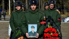 Орусиялык жоокерди көмүү жөрөлгөсү маалында.