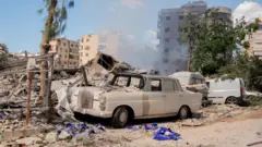 یک مرسدس بنز قدیمی در محل حمله هوایی اسرائیل در پایگاه حزب الله در ضاحیه، ۲ اکتبر ۲۰۲۴ 