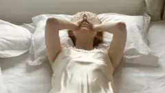 Mujer exhausta sobre la cama.