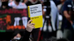 นักเรียนชูหนังสือ "ประชาธิปไตยที่มีกษัตริย์อยู่เหนือการเมือง"