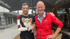 Jan, com o ombro deslocado e já em tratamento, aparece com seu cachorro Filip e Ralf, o homem que atendeu ao walkie-talkie e acionou os serviços de resgate