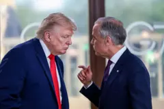両首脳がカメラに向かって横を向いて立ち、カーニー氏がトランプ氏に話しかけている