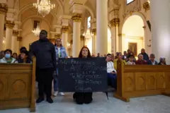 Mulher em Bogotá, Colômbia, segura cartaz dizendo que a comunidade LGBT respeita o papa Francisco, após a morte dele.