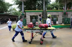 Nhân viên cứu hộ làm việc bên ngoài Trường Debsirin Nonthaburi, nơi xảy ra vụ nổ súng