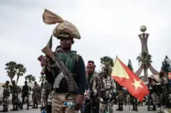 ሓይልታት ትግራይ ባንዴራ ሒዞም እናተጓዓዙ፣ ሓወልቲ ሰማእታት መቐለ ብድሕሪኦም ይርአ።