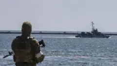 A Russian navy boat patrols the harbour in Mariupol