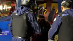 بي بي سي نیوز له پولیسو افسرانو سره د سهار په عملیاتو کې د تلیفون قاچاق کونکو ډلې په نښه کولو پرمهال