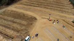 Vista de cima do cemitério com várias cruzes brancas enfileiradas